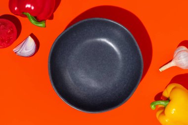 Turuncu arka planda, domates, biber, soğan ve sarımsaklı boş mavi tabak. Gazpacho malzemeleri. Yüksek kalite fotoğraf