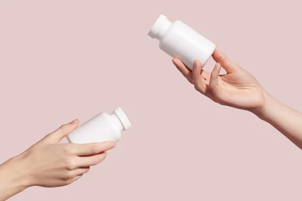 Hands Holding Blank White Plastic Tubes Pink Background Packaging Pills — Stockfoto