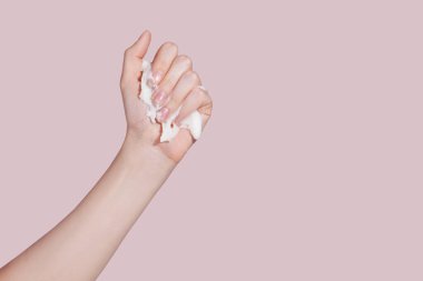 Pembe arka planı olan bir kadın eli. Deri bakımı konsepti. Yüksek kalite fotoğraf