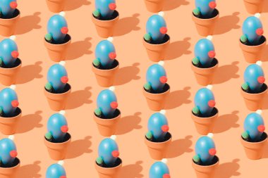 Mavi kaktüsün yaratıcı renkli deseni kahverengi arka plandaki saksılarda yumurtalar şekillendirdi.