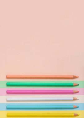 Multicolored pencils lined up on a multicolored background. Abstract minimal concept. Top view, flat lay. Rectangle with copy space Back to school idea