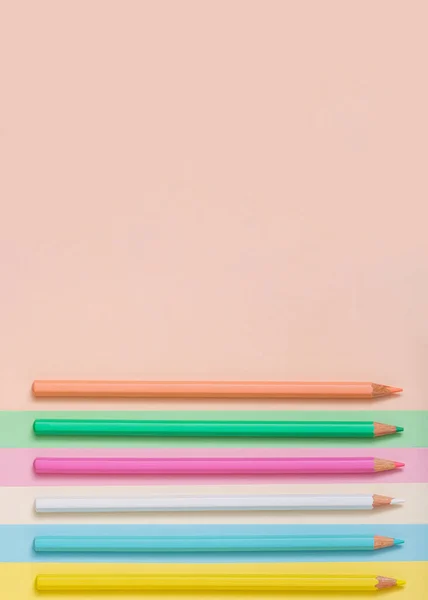 Multicolored pencils lined up on a multicolored background. Abstract minimal concept. Top view, flat lay. Rectangle with copy space Back to school idea