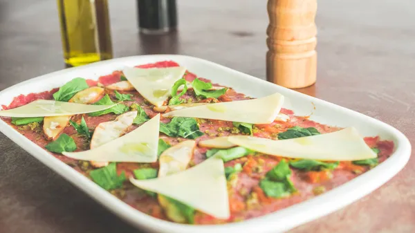 Parmesan peyniri ve roka ile etli carpaccio aperatifi.