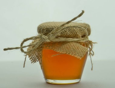 - Tatlım. Beyaz arka planda ballı kırsal ve el yapımı cam kavanoz. Sağlıklı gıda konsepti.