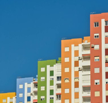 Derin mavi gökyüzüne karşı merdiven şeklinde görsel efektleri olan renkli binalar. Geometri.