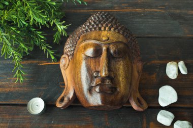 Image of Buda on wooden background. Incense and aromatic candles on dark background. Spa, wellness and beauty concept.
