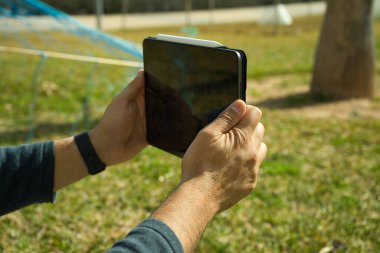 Güneşli bir günde dışarıda dijital tablet ve stil tutan eller.