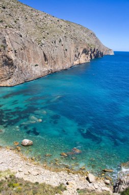 Güneşli bir günde Mascarat, Altea, Comunidad Valenciana, İspanya 'daki Raco del Corb kayalıklarında hava manzarası. Kristal berrak turkuaz suları olan vahşi ve ıssız bir sahil..