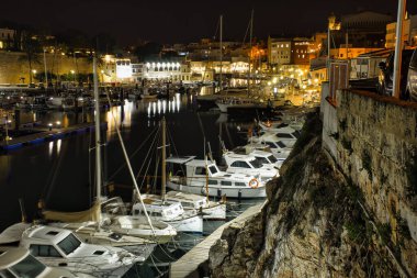 CIUDADELA, MENORCA: 15 Nisan 2022: gece kalenin güzel ve görkemli panoramik manzarası, tatilde ziyaret etmek için ünlü ve turistik bir yer.