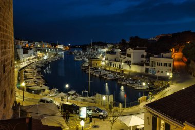 CIUDADELA, MENORCA: 15 Nisan 2022: gece kalenin güzel ve görkemli panoramik manzarası, tatilde ziyaret etmek için ünlü ve turistik bir yer.