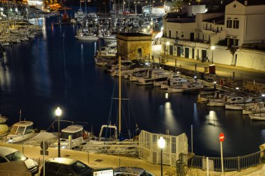 CIUDADELA, MENORCA: 15 Nisan 2022: gece kalenin güzel ve görkemli panoramik manzarası, tatilde ziyaret etmek için ünlü ve turistik bir yer.