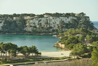 MENORCA, Balearik Adaları, İspanya. 15 Nisan 2022: Cala Galdana 'da panoramik manzara, bahar ve yaz tatillerinde sıkça ziyaret edilen ünlü plaj, çoğunlukla aileler ve çiftler tarafından ziyaret ediliyor..
