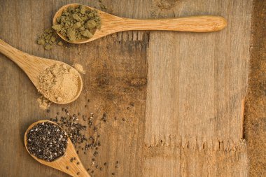Tahta kaşıklar üzerinde süper yiyeceklerin kırsal bileşimi. Maca, Chia ve Hemp Protein. Hepsi de vitamin ve omega-3 kaynağı. Sağlıklı yaşam tarzı ve diyet konsepti. Üst görünüm.