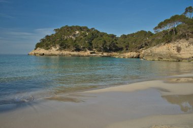Paradisaik bir plajın panoramik manzarası. Güneşli bir günde mavi gökyüzü ile birlikte deniz kenarında doğaya yapılan tatil gezilerinin ilham verici bir sahnesi. Metin için alanı kopyala.