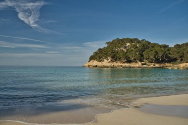 Paradisaik bir plajın panoramik manzarası. Güneşli bir günde mavi gökyüzü ile birlikte deniz kenarında doğaya yapılan tatil gezilerinin ilham verici bir sahnesi. Metin için alanı kopyala.