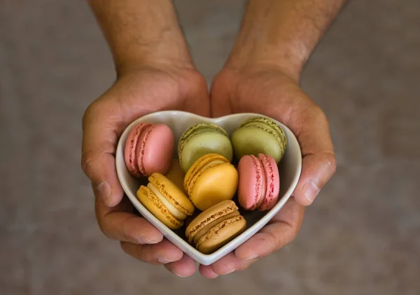 Thank you gift with colorful macaroons inside a heart shaped box on blurred background. Food concept