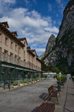 LA HERMIDA, CANTABRIA, İspanya, 8 Temmuz 2022: Balnear de La Hermida 'nın ana binasının ön cephesi ve arka planda dağların bulunduğu olağanüstü doğal yerleşim alanı.