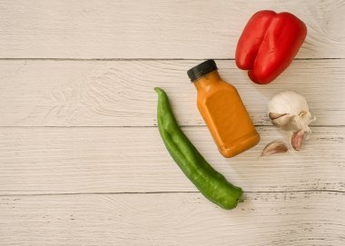 Low calorie diet. Cold vegetable soup for the summer served in a bottle, ready to take to the beach or the field for a picnic. Fresh and healthy food. White wooden table.