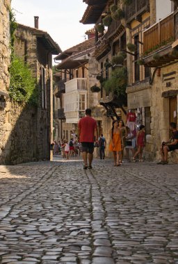 SAN VICENTE DE LA BARQUERA, CANTABRIA, SPAIN, JULY 13, 2022: Views of the old town of San Vicente de la Barquera, cobbled streets and details of buildings and people walking through its streets.