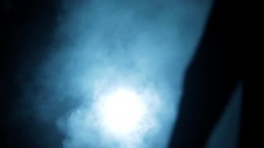 Elinde silahla dolaşan bir mafya adamının sinematik yavaş çekim görüntüleri. Etrafında duman bulutları olan karanlık bir adamın dramatik görüntüsü. Yüksek çözünürlüklü görüntüler.