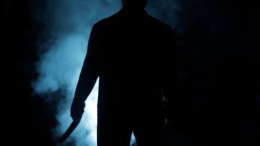 Dramatik ışıkta yürüyen takım elbiseli bir adamın sinematik görüntüleri ve etrafında biraz sis. Yürüyen bir adamın karanlık görüntüsü. Yüksek çözünürlüklü görüntüler.