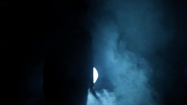 劇的な照明と彼の周りのいくつかの霧の中を歩くスーツの男の映画撮影 歩く男の暗いショット 高解像度映像 — ストック動画