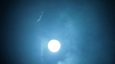 Uzun paltolu bir adam elinde bir balta, dramatik bir ışıkla yürüyor..