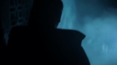 B rolünde bir kadın dramatik bir ışıkla aşağıya iniyor..