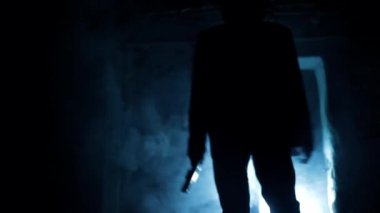 Cinematic shot of a serial killer in a suit coming out of the door and shooting with smoke and dramatic lighting. 