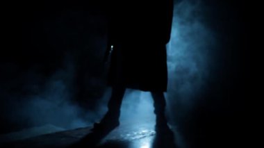 Cinematic shot of a professional killer in long court with a handgun in dramatic light, and smoke.