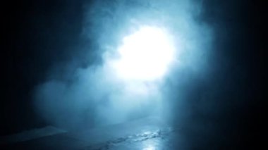 Professional hitman in long court with a gun in his hand, dramatic lighting and smoke.