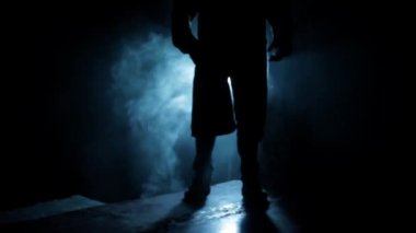 Professional hitman in a suit with a gun in his hand, dramatic lighting and smoke.