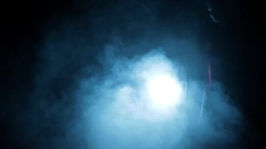 Professional hitman in long court with a gun in his hand, dramatic lighting and smoke.