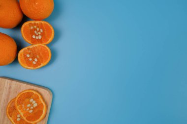 Mavi arka plandaki tarlalardan taze sarı portakallar.