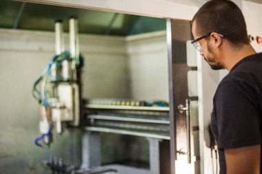 CNC 'de çalışan mühendis teknisyen fabrika atölyesinde metal oyma makinesi işliyor..