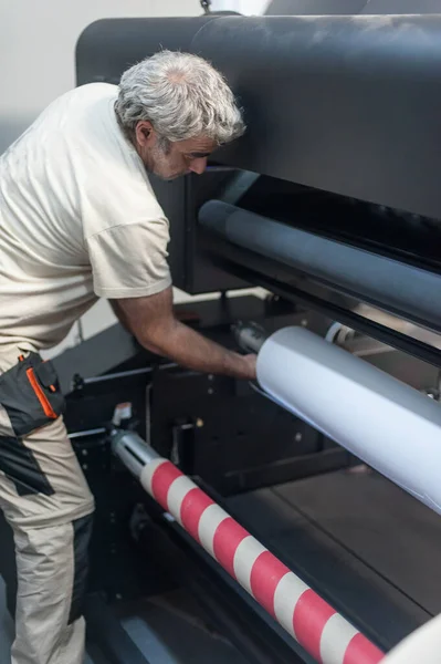 数字印刷厂车间大型高档工业打印机和绘图机上的纸卷更换 — 图库照片