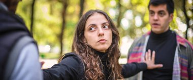 Kadın kavga halindeki iki saldırgan, sinirli, sinirli ve sinirli adamı ayırmaya çalışır ve aralarında kollarını açarak durur. Grup kavgası kavramı