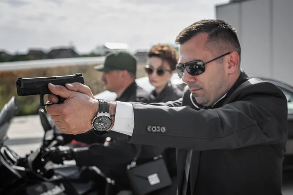 Tactical exercise training. An armed bodyguard security team protects a celebrity vip person in danger combat situation when attacked. Security police team in civilian black suit with sunglasses