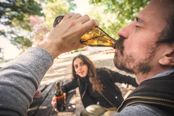 Jovem Casal Bebendo Cerveja Garrafa Banco Madeira Com Mesa Parque — Fotografia de Stock