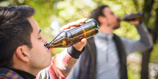 Two Men Chugging Beer Bottle Wooden Bench Table Forest Park — Stock Photo, Image