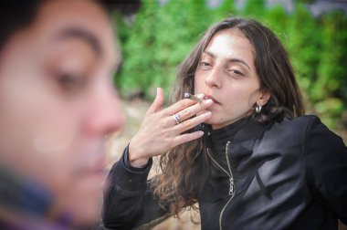 Genç bir çift, kadın ve erkek, kenevir marihuanası içiyorlar ya da açık hava parkında esrar içiyorlar. Kadın ve erkek birlikte thc yeşil ot içerler. Gerçek hayat sahnesi konsepti