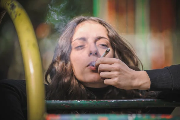若い女性の詳細なビューは 大麻マリファナガンジャまたはハッシュジョイントタバコを吸う カジュアルな女性の女の子は緑の草を吸う リアルライフシーンのコンセプト — ストック写真