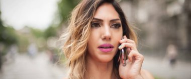 Moda mankeni genç bayanın cep telefonuyla konuştuğu yakın çekim detay görüntüsü. Şehir modası ve moda kıyafet konsepti