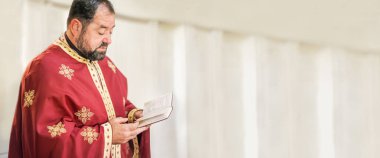 Kilise ayini sırasında dindar bir rahip. Otantik dini tören. Mesaj için boş bir yer. Kutsal İncil kitabı. İnanç, umut, ruh ve barış ritüeli. Gerçek hayat sahnesi