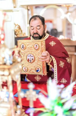 Kilise ayini sırasında dindar bir rahip. Otantik dini tören. Kutsal kitap ve haç. İnanç, umut, ruh ve barış ritüeli. Gerçek hayat sahnesi