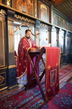 Kilise ayini sırasında dindar bir rahip. Otantik dini tören. Kutsal kitap ve haç. İnanç, umut, ruh ve barış ritüeli. Gerçek hayat sahnesi