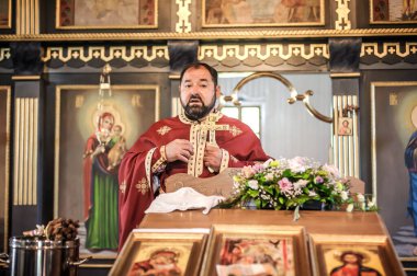 Kilise ayini sırasında dindar bir rahip. Otantik dini tören. Kutsal kitap ve haç. İnanç, umut, ruh ve barış ritüeli. Gerçek hayat sahnesi