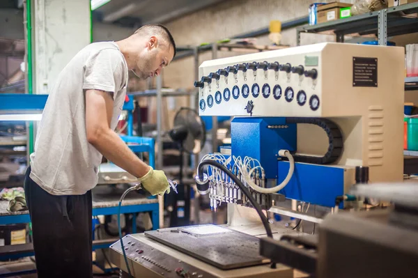 Fabrika üretim işyerinde yumuşak PVC dağıtım makinesiyle çalışan profesyonel makinist mühendis teknisyeni. Endüstriyel çalışma süreci