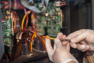 Elektrik mühendisi operatörünün yakın plan detaylı görüntüsü dijital matbaa ofisindeki büyük kaliteli endüstriyel yazıcı ve çizer makinesini tamir ediyor