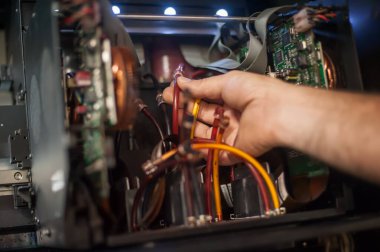 Elektrik mühendisi operatörünün yakın plan detaylı görüntüsü dijital matbaa ofisindeki büyük kaliteli endüstriyel yazıcı ve çizer makinesini tamir ediyor